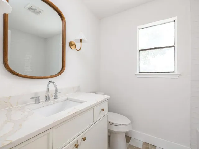 a bathroom with a sink toilet and mirror