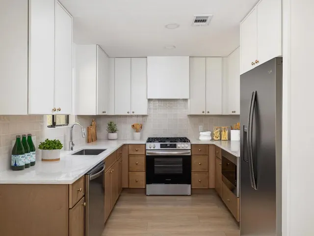 a kitchen with stainless steel appliances granite countertop a stove a sink dishwasher and a refrigerator