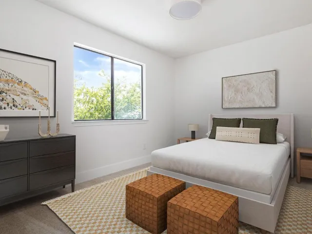 a bedroom with a bed and a dresser next to a window