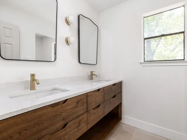 a bathroom with a double vanity sink and mirror