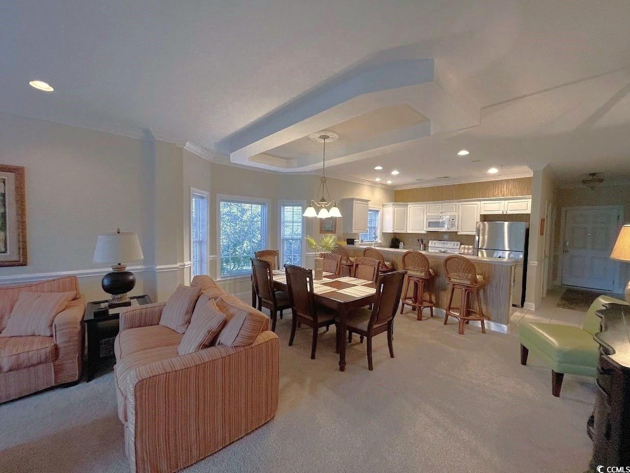 1008 Ray Costin Way, Unit 310 Murrells Inlet, SC 29576 - Photo 18 of 40 Carpeted living room featuring an inviting chandelier and ornamental molding