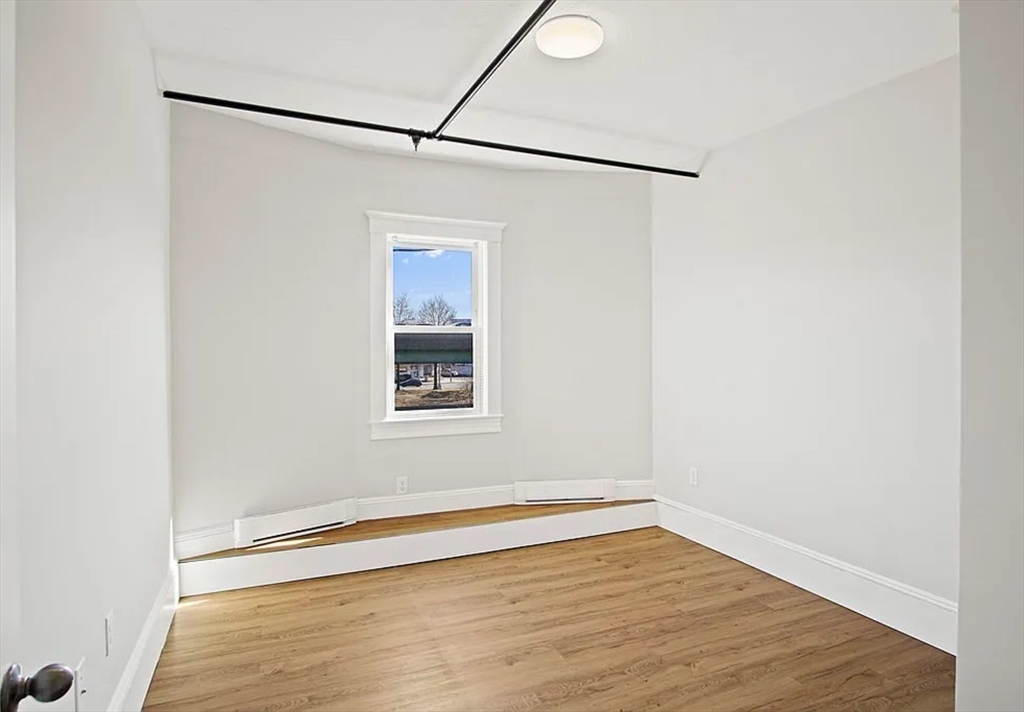 2 Redfield Street, Unit 2 Boston, MA 02122 - Photo 10 of 14 a view of an empty room with a window and wooden floor