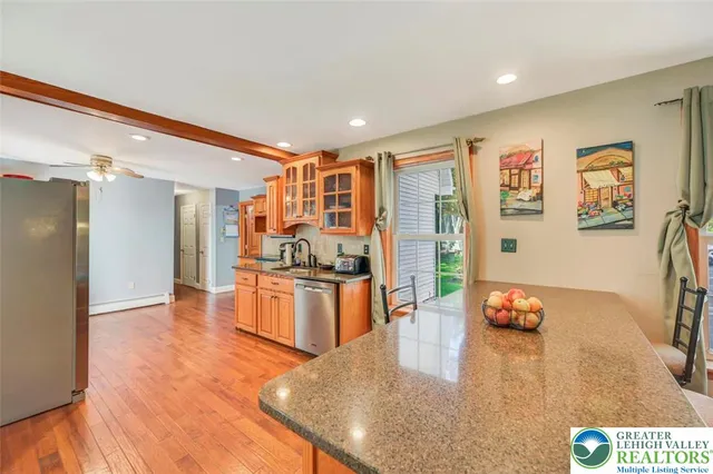 a large kitchen with stainless steel appliances granite countertop a stove and a refrigerator