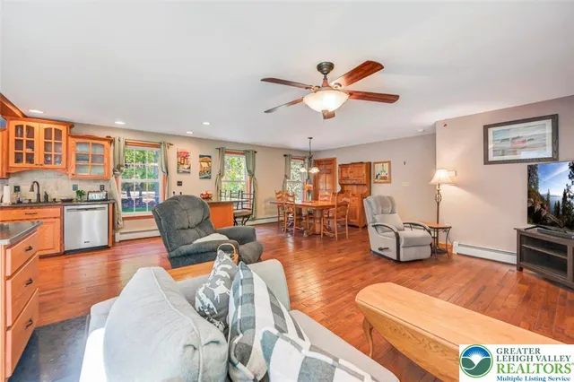 a kitchen with stainless steel appliances a sink a stove a refrigerator cabinets and a window