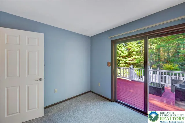 a view of a brick house with large windows and a small yard