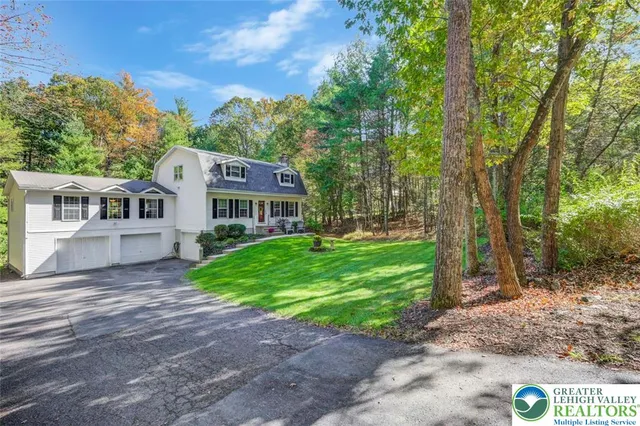 an empty room with windows a fireplace a ceiling fan and wooden floor