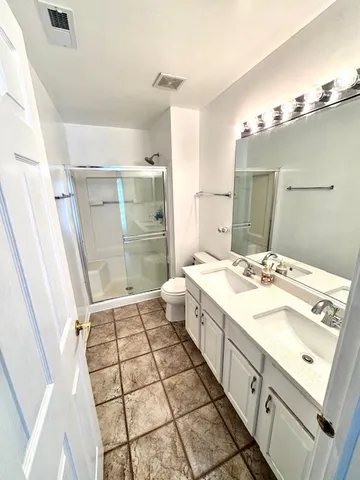 a bathroom with a sink mirror and shower