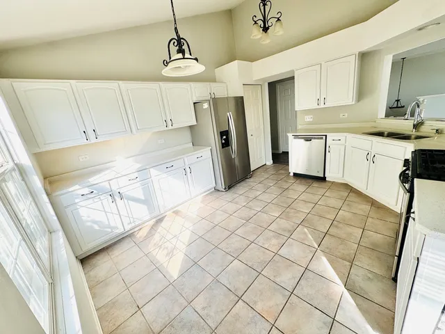a kitchen with a sink a refrigerator and cabinets