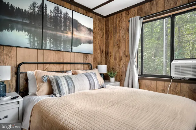 a bedroom with a bed and a large window with outer view