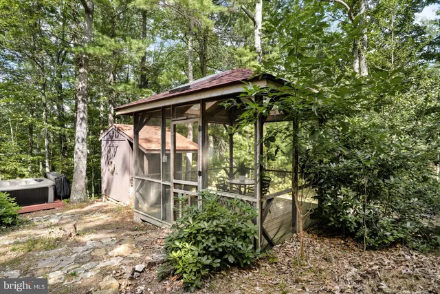 a backyard of a house with large trees and plants
