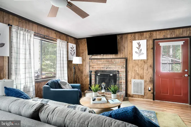 a living room with furniture fireplace and a large window