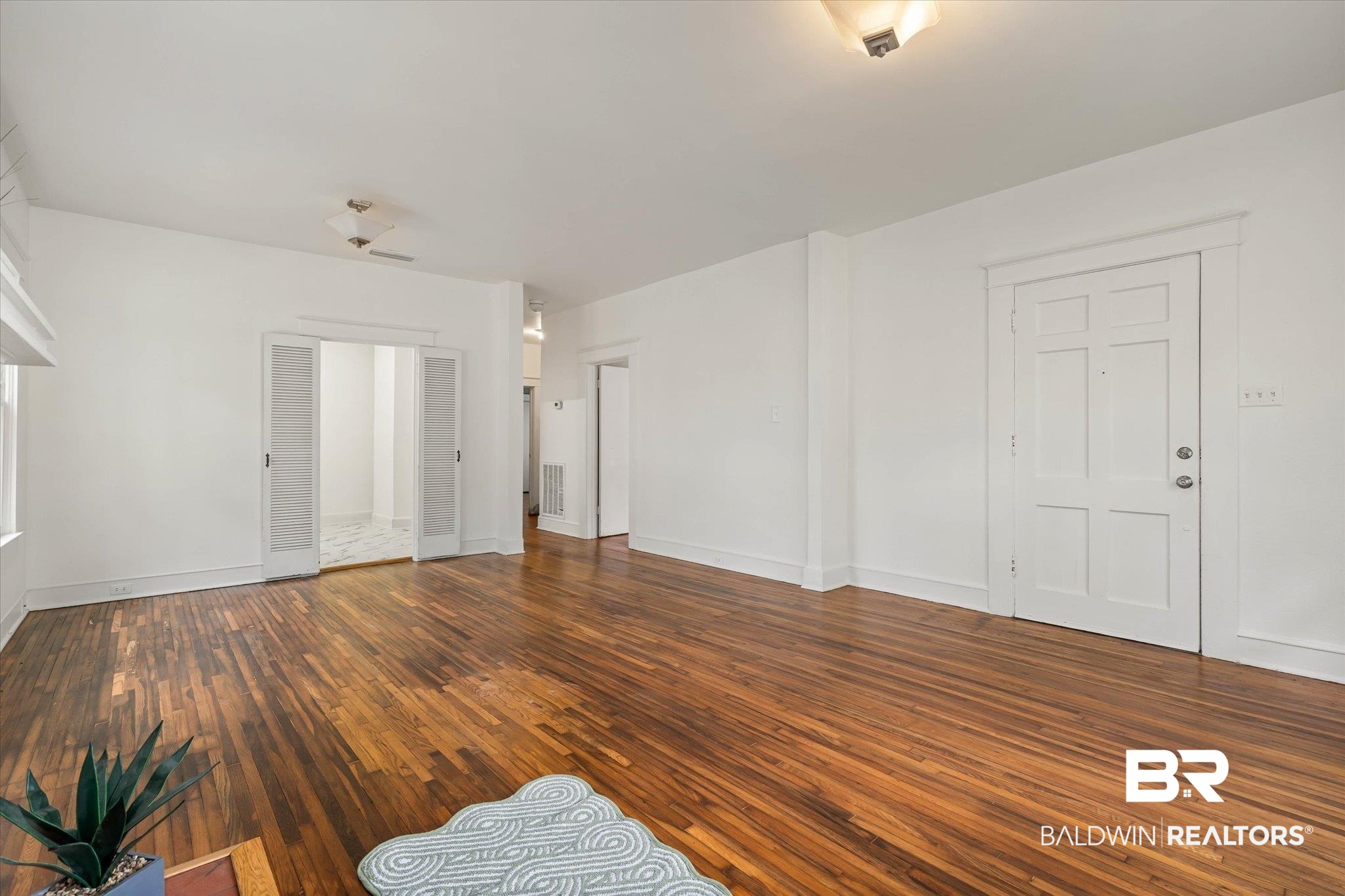 121 Westwood Street Mobile, AL 36606 - Photo 3 of 20 Unfurnished living room featuring baseboards, hardwood / wood-style floors, and visible vents