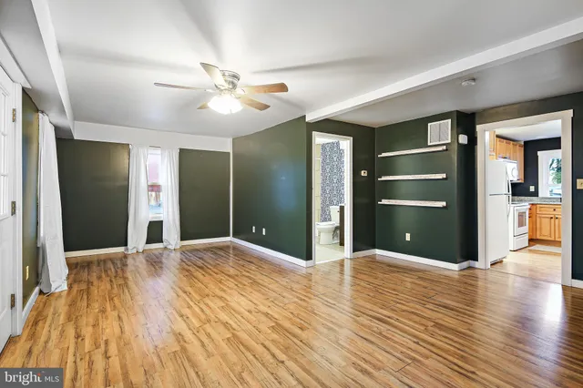 a view of empty room with wooden floor