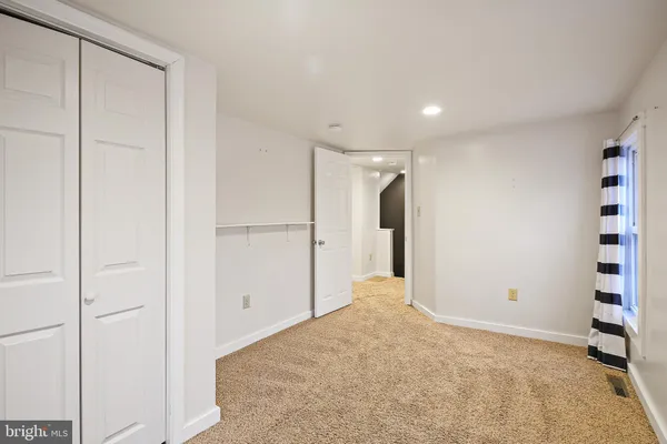 a bedroom with a bed a dresser and a window