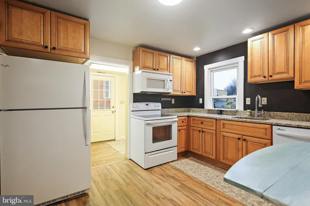 a kitchen with stainless steel appliances granite countertop a refrigerator a stove top oven a sink and dishwasher