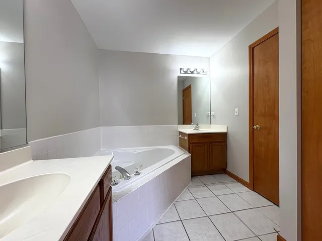 a bathroom with a bathtub sink and a mirror
