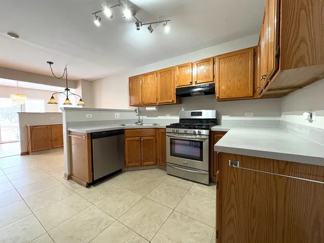 a kitchen with stainless steel appliances granite countertop a stove a sink dishwasher and a refrigerator
