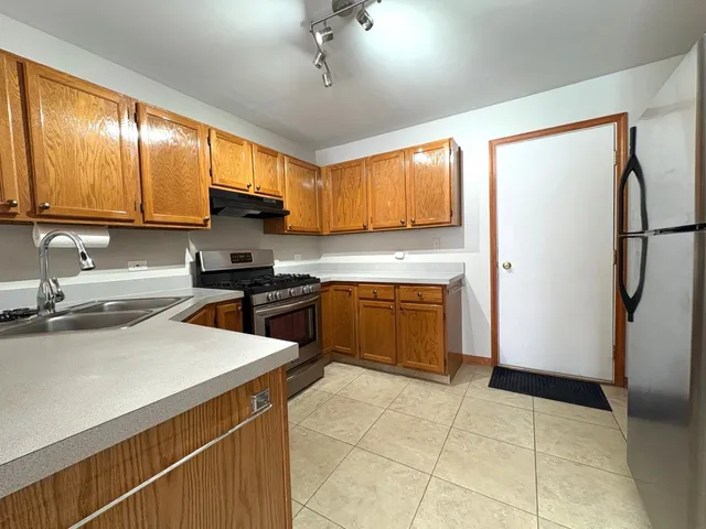 a kitchen with a sink a refrigerator and cabinets