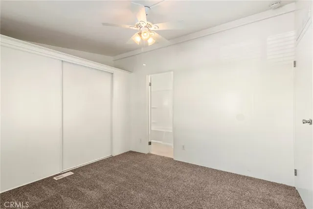 an empty room with a ceiling fan and a window