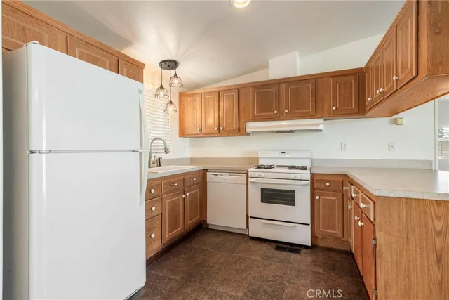 a kitchen with stainless steel appliances granite countertop a refrigerator a sink and a stove