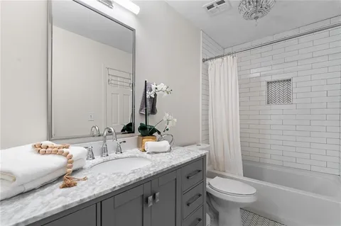 a bathroom with a granite countertop sink toilet and shower