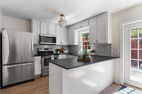 a kitchen with a refrigerator a microwave a sink and cabinets