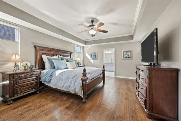 a bedroom with a bed and a flat tv screen on dresser