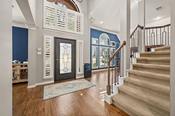 a view of a hallway with wooden floor and staircase