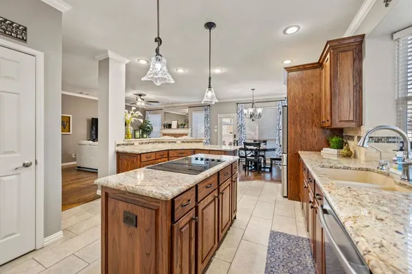 a kitchen with kitchen island granite countertop a sink stove and a refrigerator