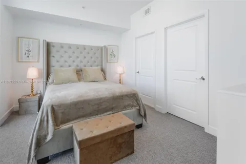 a bedroom with a large bed and flat tv screen on the dresser