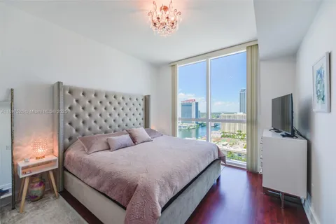 a spacious bedroom with a bed and a chandelier