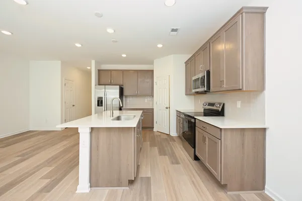 a kitchen with stainless steel appliances a refrigerator sink and microwave
