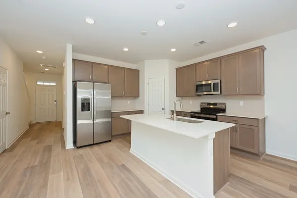 a kitchen with granite countertop a refrigerator and a stove top oven