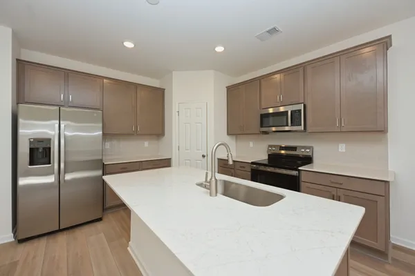 a kitchen with sink a microwave and refrigerator