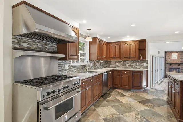a kitchen with stainless steel appliances granite countertop a stove a sink and a microwave