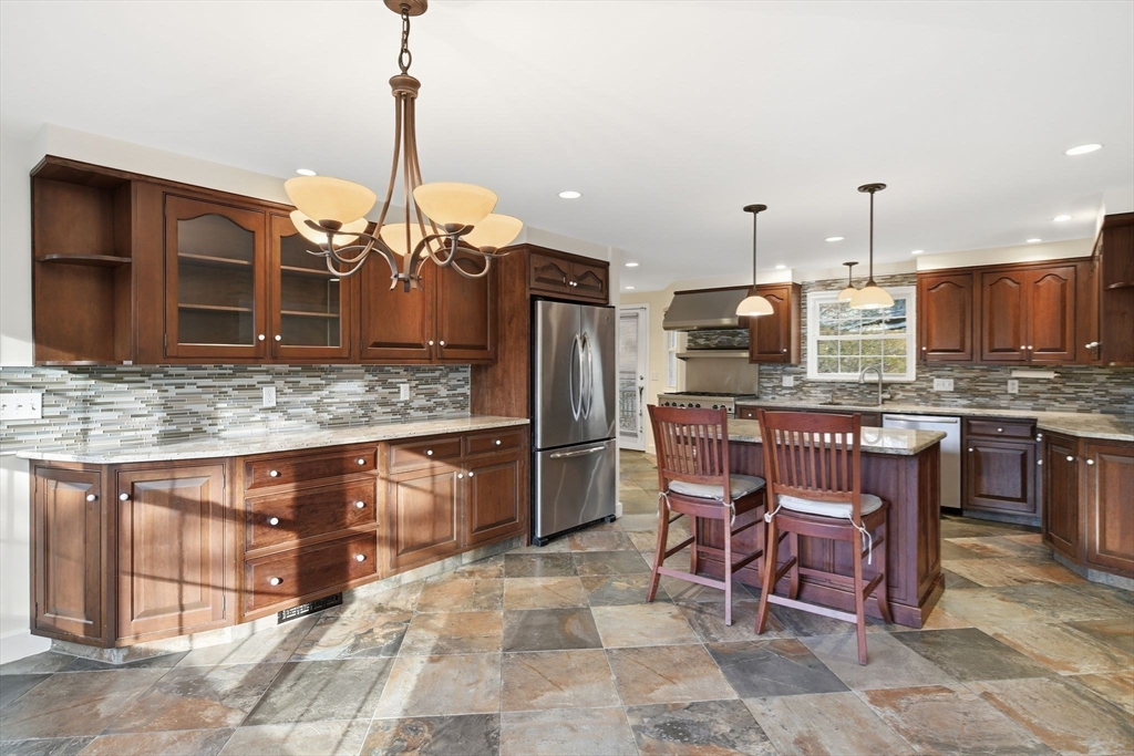 68 Monson Road Wilbraham, MA 01095 - Photo 17 of 39 a kitchen with kitchen island granite countertop a table chairs microwave and refrigerator