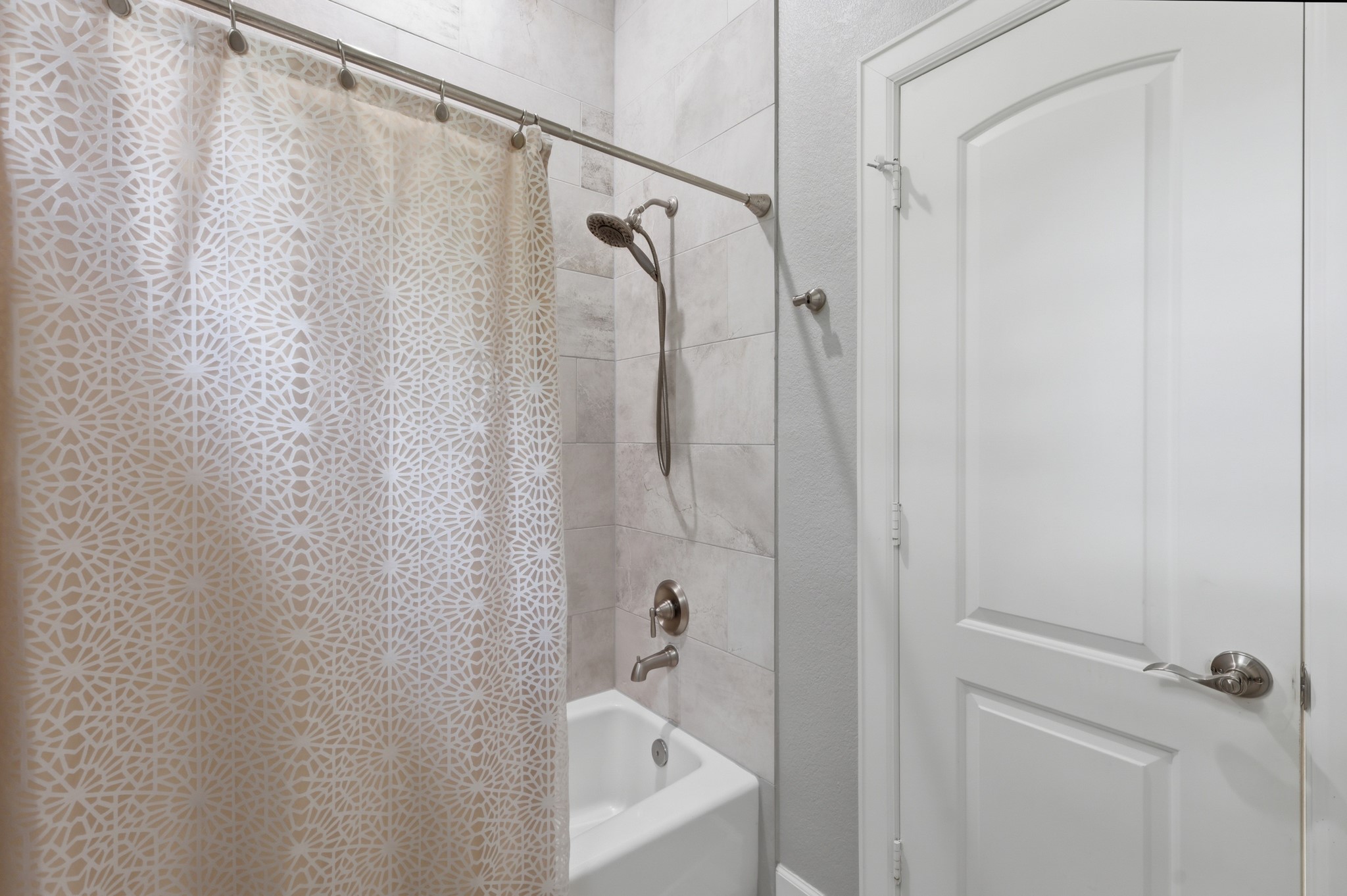 7106 Hampton Court Spring, TX 77389 - Photo 17 of 31 Guest bathroom features a modern shower with sleek tile walls, and a white door, creating a clean and stylish look.