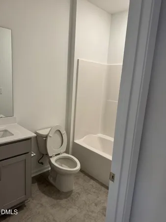 a white toilet sitting next to a bath tub