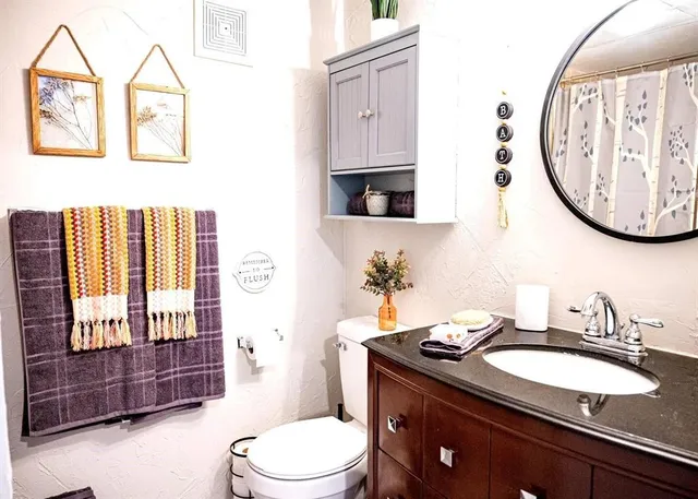 a bathroom with a toilet sink and mirror