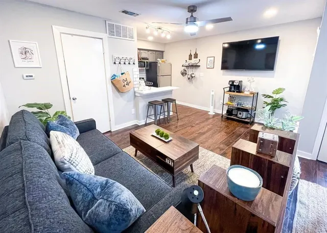 a living room with furniture and wooden floor