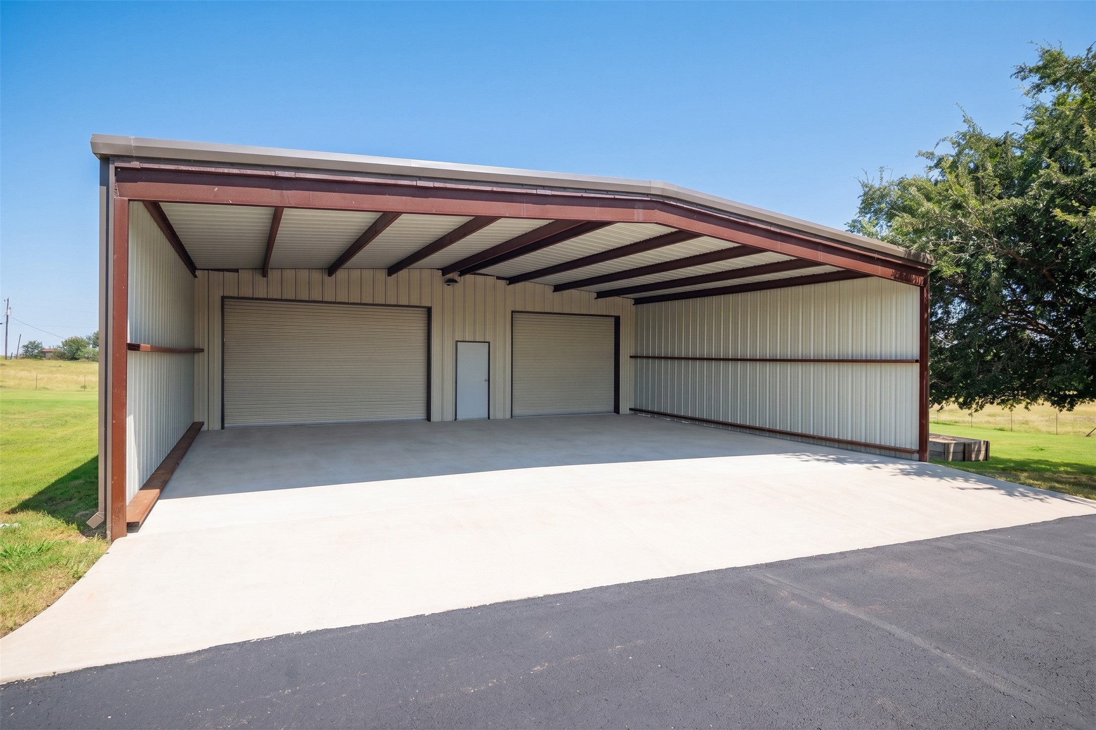 20145 Janak Road Coupland, TX 78615 - Photo 29 of 40 A spacious, newly constructed metal workshop with multiple garage doors for ample storage.