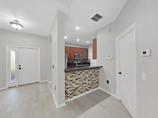 an empty room with ceiling fan and window
