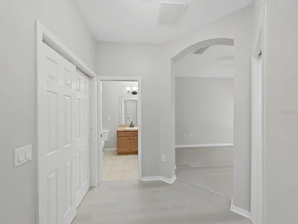 an empty room with closet and windows