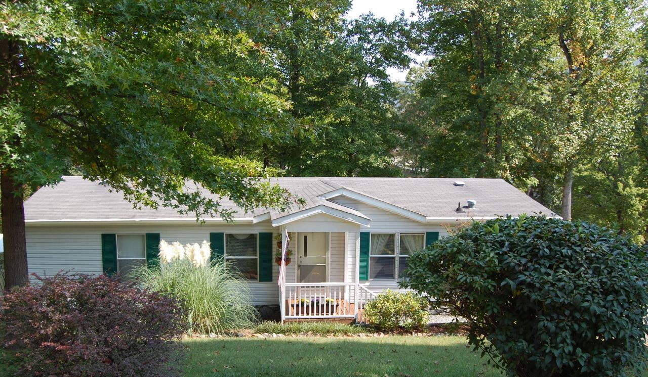 180 Cove Road Penhook, VA 24137 - Photo 24 of 33 a view of a white house with a big yard and large trees