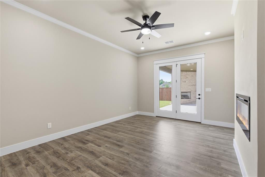 709 Anne Road Van Alstyne, TX 75495 - Photo 10 of 28 Bright interior with wood-finish flooring, crown molding, and a ceiling fan with integrated lighting