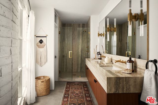 a en suite bathroom with a double vanity sink a mirror and a shower