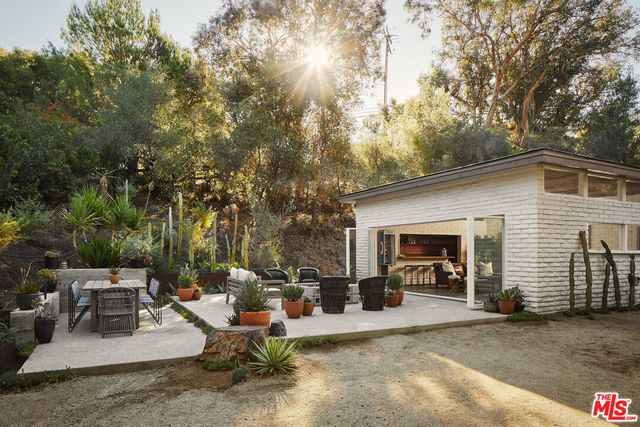 a view of a patio with couches and table and chairs next to yard