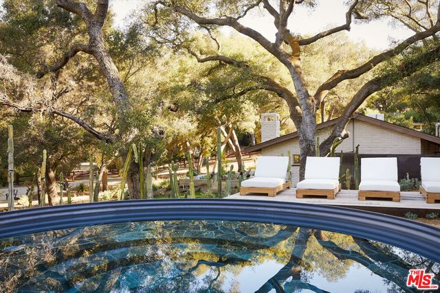a view of a roof deck with a bench and trees