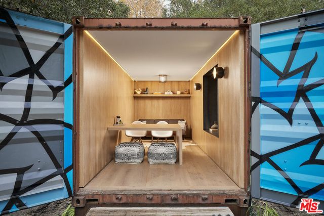 a living room with table chairs and a potted plant