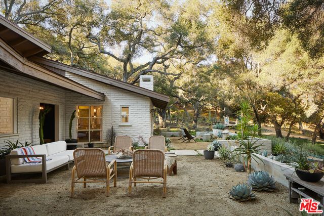 a view of a patio with table and chairs and potted plants